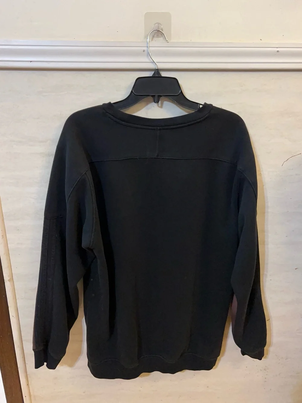 A upcycled, custom bleach-splattered Adidas crewneck sweatshirt